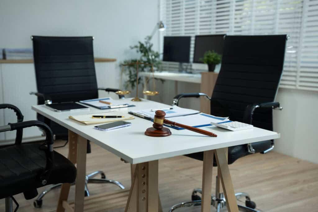 Workspace with desktop computer, office supplies, houseplant and coffee cup at a lawyer’s office.