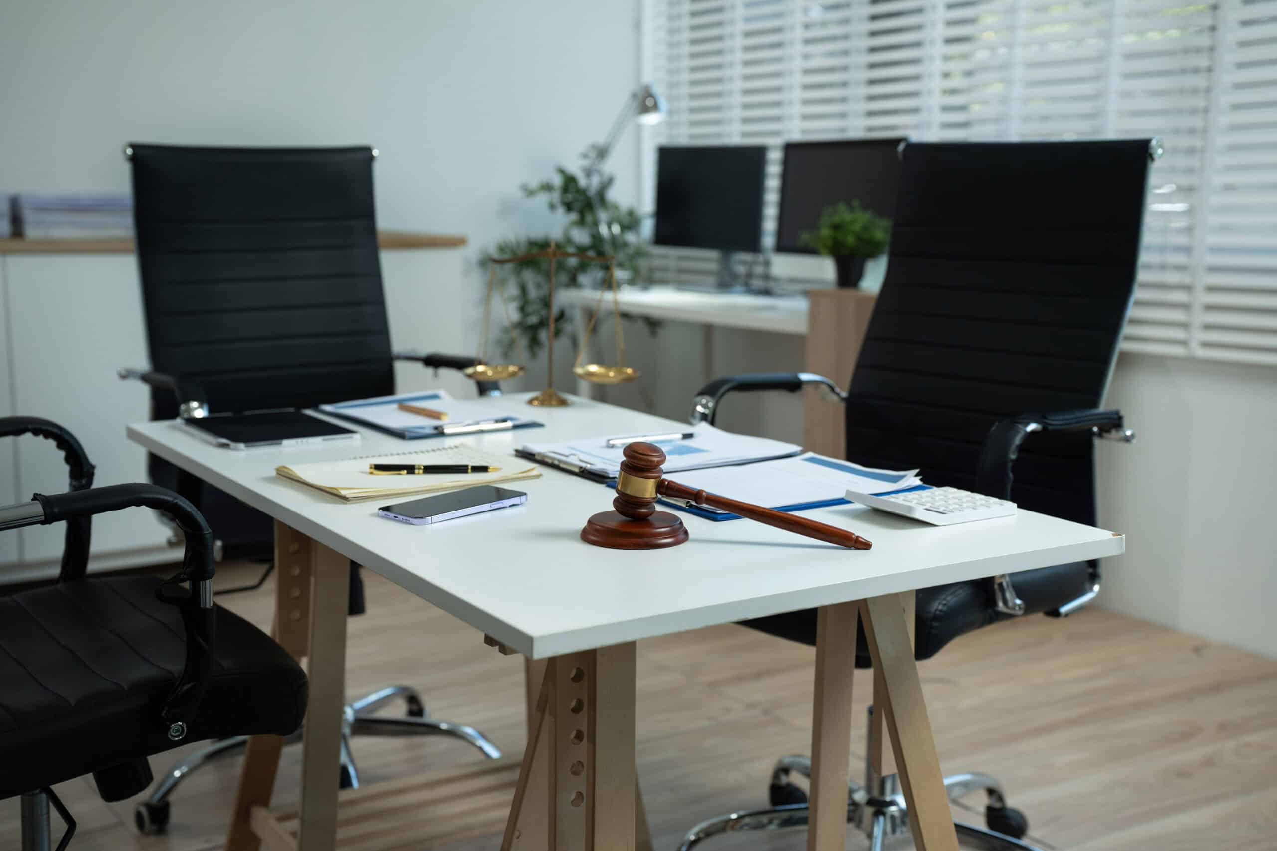 Workspace with desktop computer, office supplies, houseplant and coffee cup at a lawyer’s office.