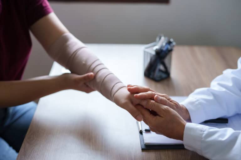 Doctor examining a patient’s arm injury after a slip and fall accident during a medical evaluation